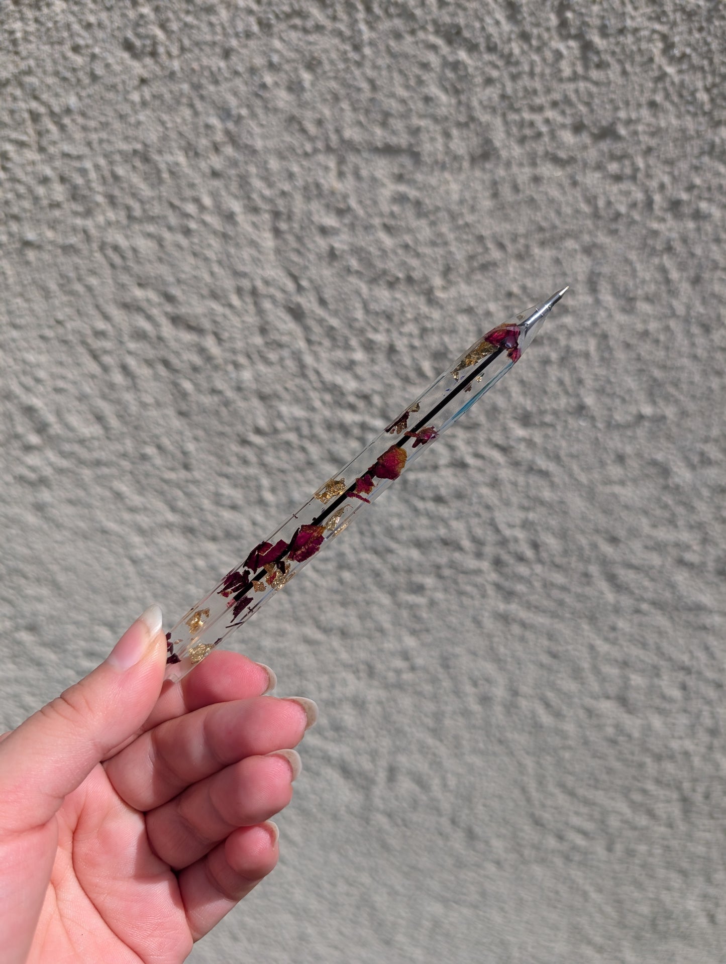 Stylo avec feuille d'or et pétales de rose