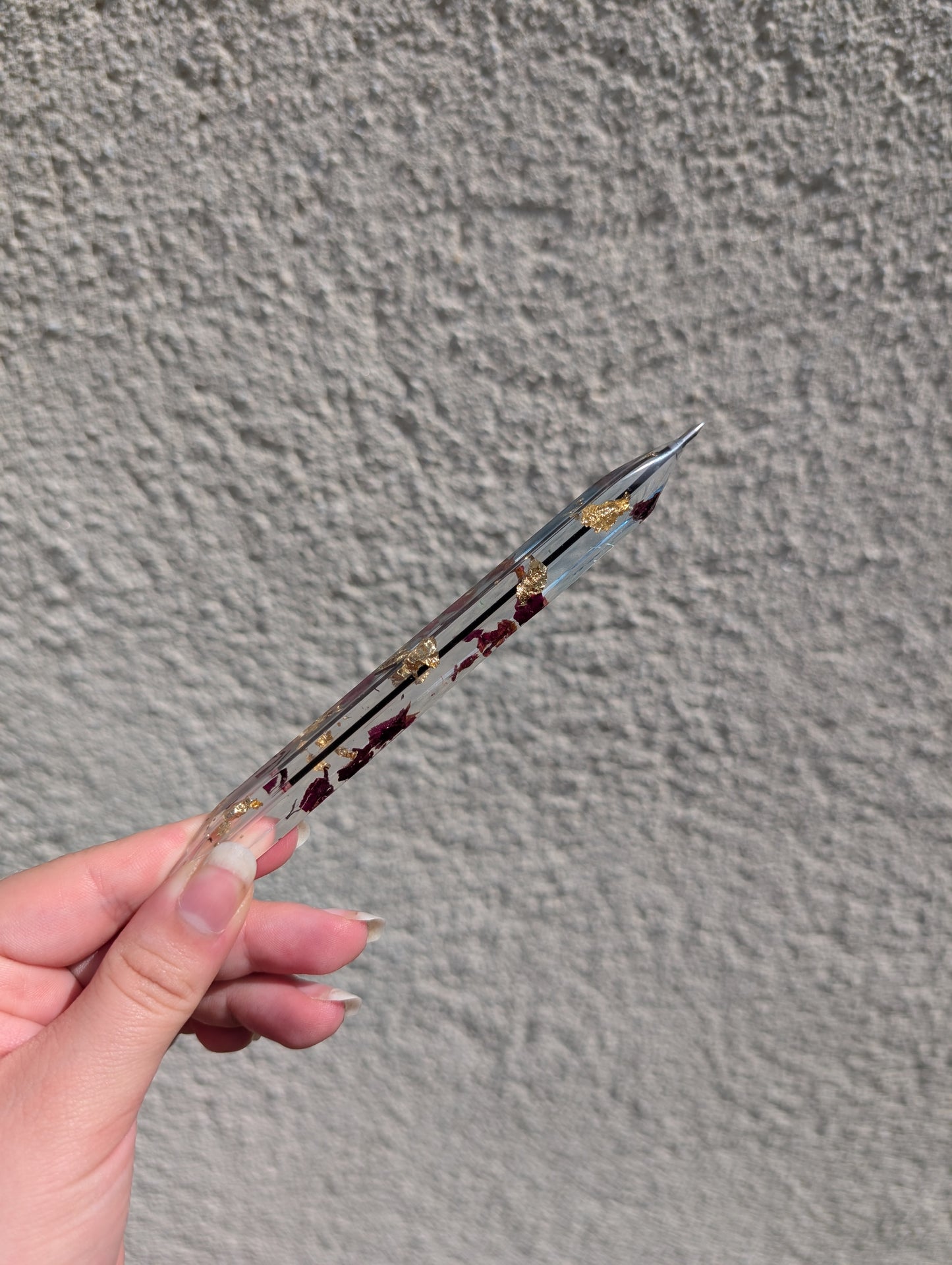 Stylo avec feuille d'or et pétales de rose