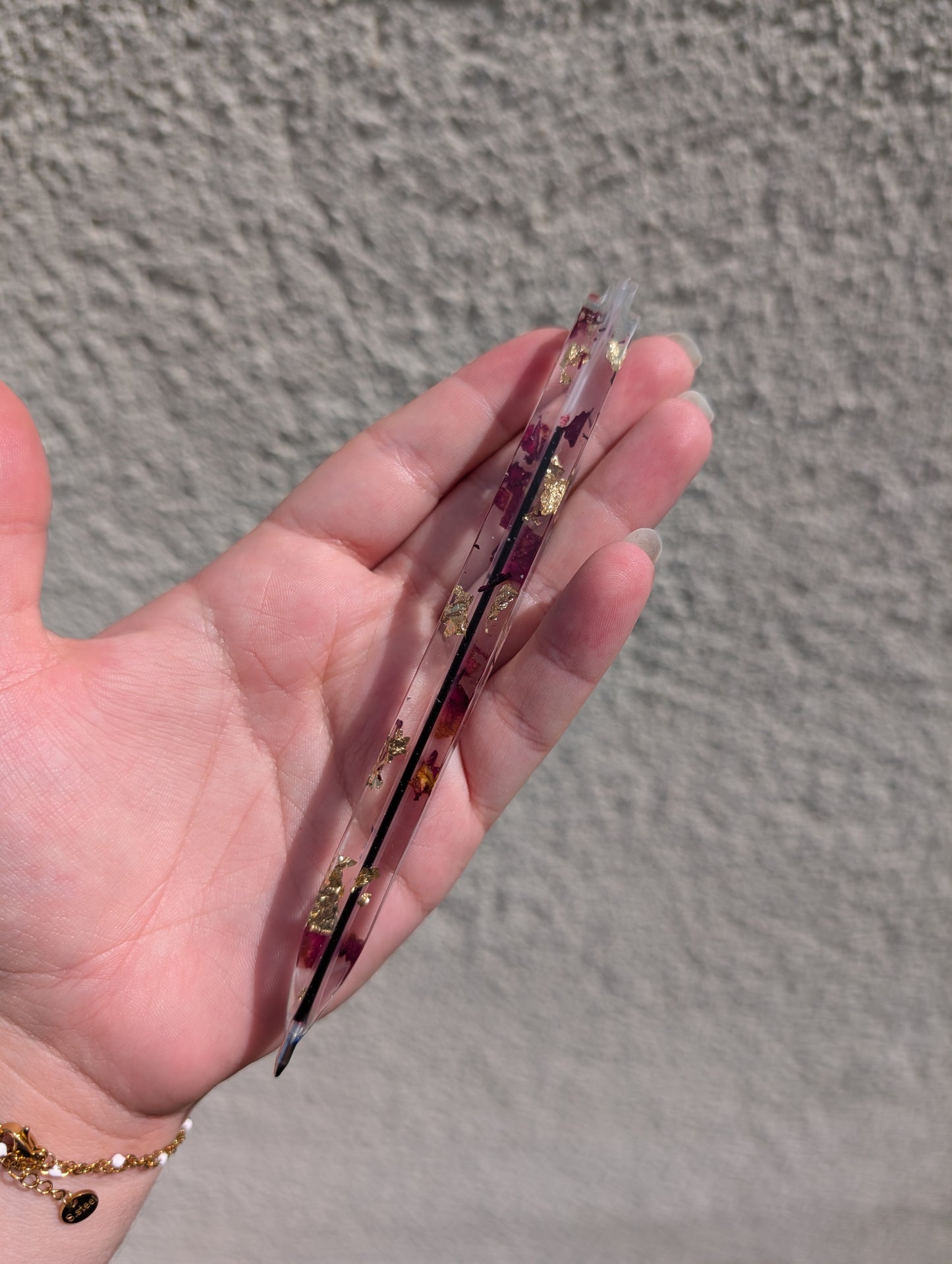 Stylo avec feuille d'or et pétales de rose